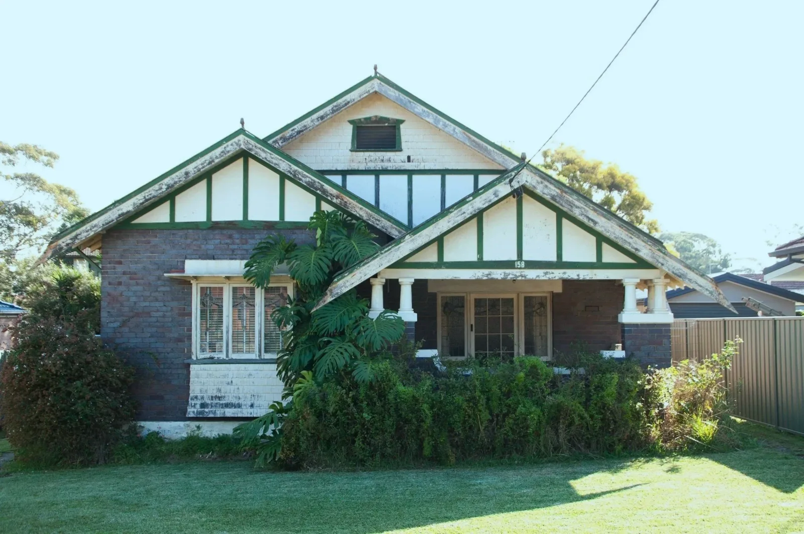 Building inspector checking a modern home's exterior and roofline